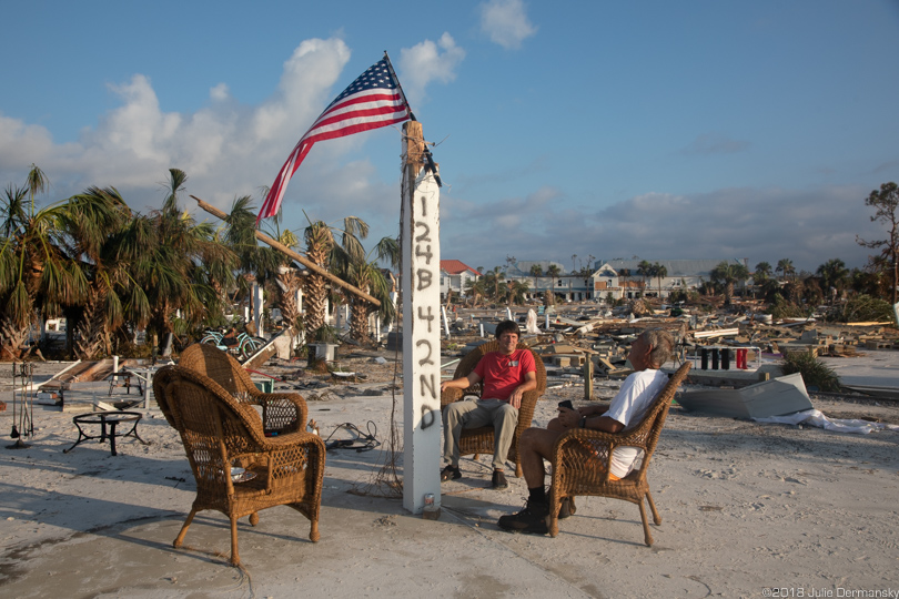 Russell King and his nephew Dr. Lebron Lackey sit in chairs amid hurricane debris
