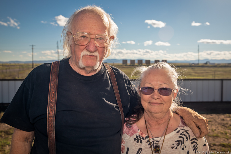 Franklins in front of their West Texas home with fracking sites all around