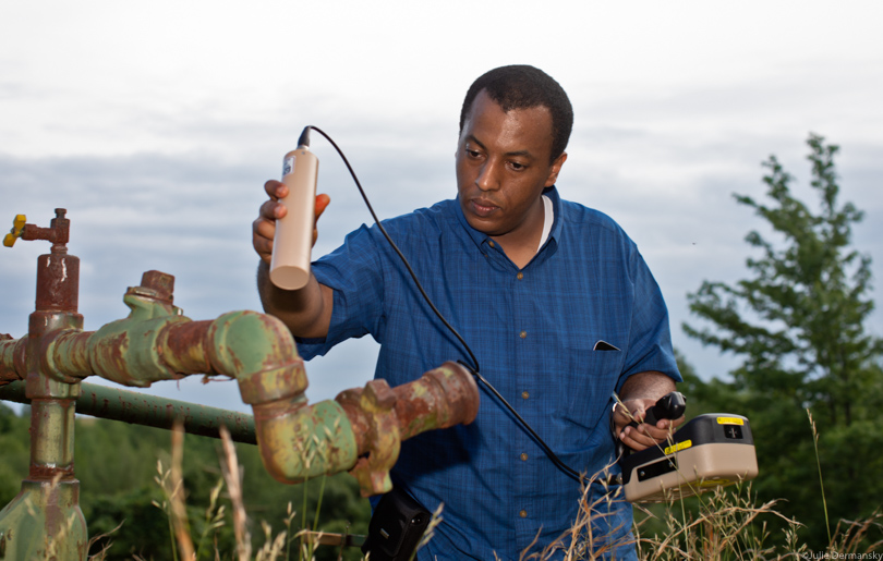 NRDC scientist Bemnet Alemayehu checking a gas well for radiation in Indiana Country, PA.  