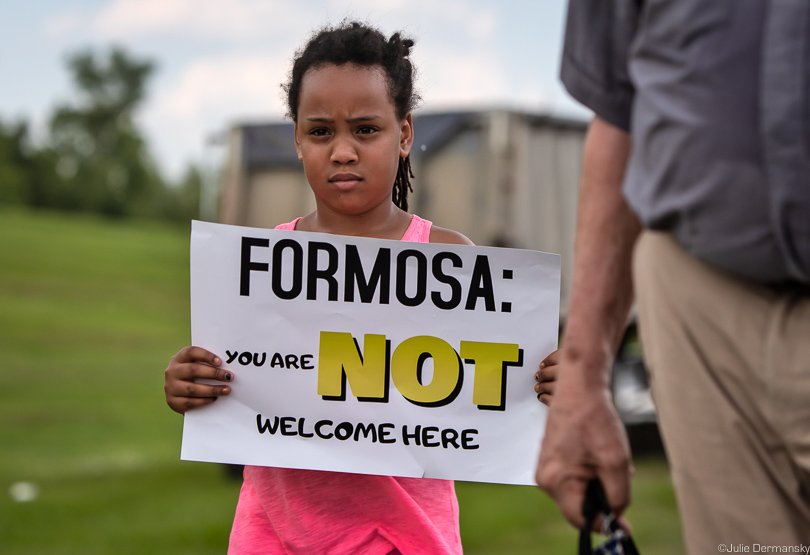 Child holding sign about a proposed Formosa petrochemical plant