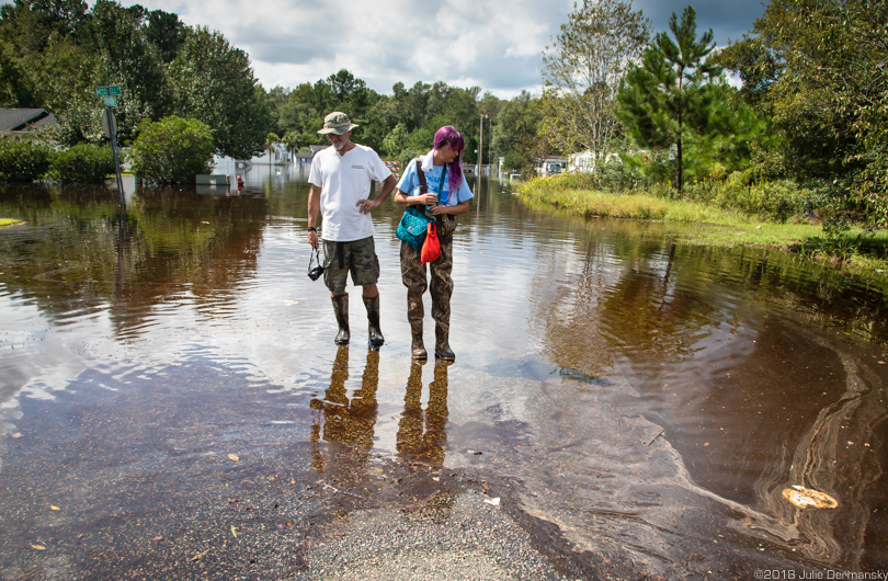 Jane (right) and Chris Ochsenbein stand in polluted floodwaters