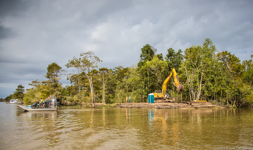 Ongoing construction work moves land in Atchafalaya Basin, surrounded by high water