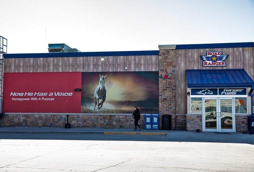 Sign glorifying the American West at gas station in Pecos, Texas