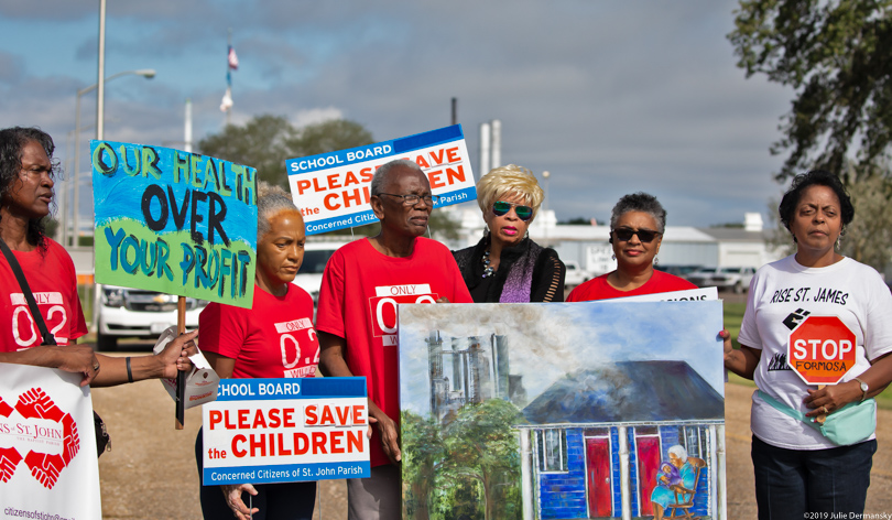 Concerned Citizens of St. John hold signs and protest outside Denka's neoprene plant