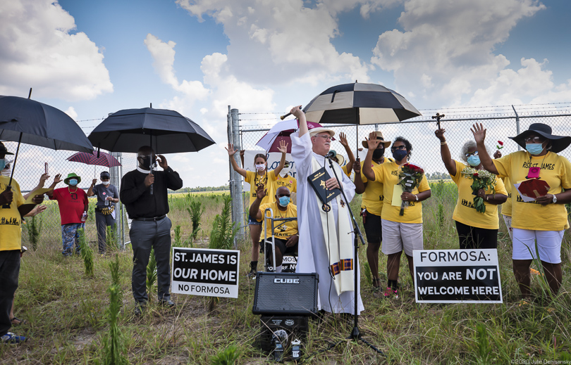 Fr. Vincent Dufresne spreading holy water over the former burial ground of enslaved African Americans on Juneteenth