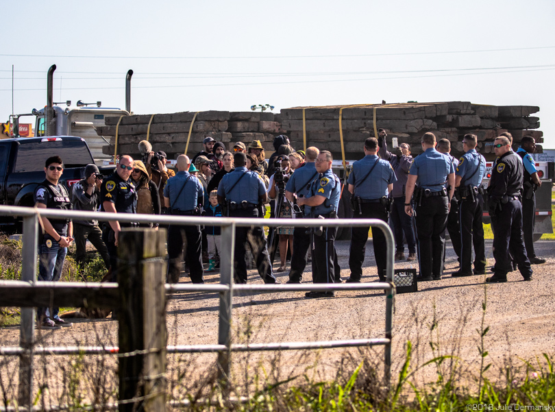 A large group of law enforcement officers and protesters at the site of the demonstration