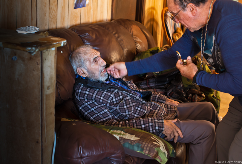 Chief Albert Naquin delivers communion to an elder member of the Isle de Jean Charles Tribe.