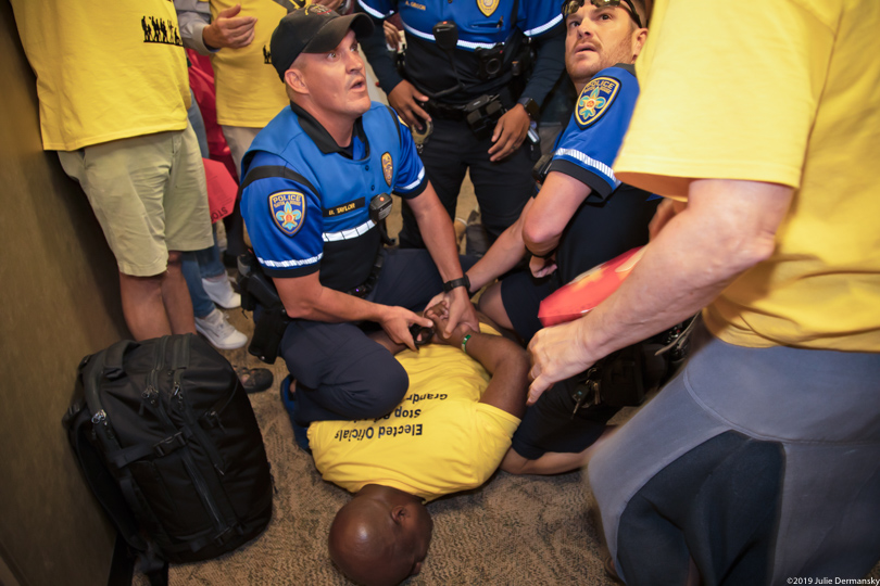 Pastor Gregory Manning being pinned to the ground by two police officers