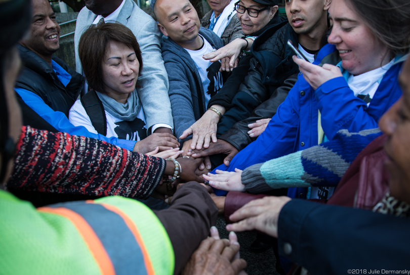 The coalition against Entergy's gas plant put their hands in the center of a circle