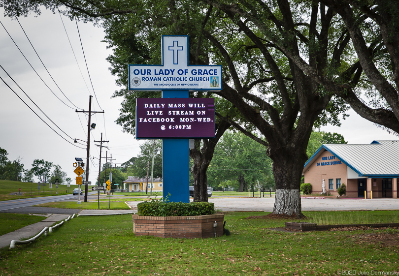 Church in Reserve, Louisiana, with a sign about live-streaming mass on Facebook