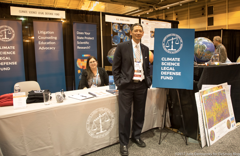 Scott Mandia stands by the Climate Science Legal Defense Fund at the American Geophysical Union meeting exhibition hall.