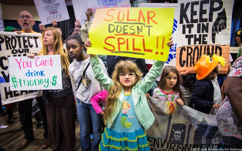 Children holding signs in a protest in the New Orleans Superdome against a federal auction of Gulf of Mexico drilling leases.
