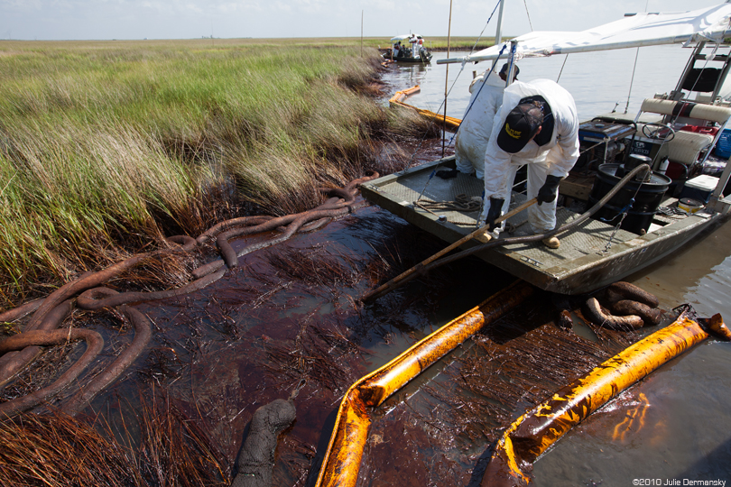 Workers use absorbent boom on the BP oil spill in 2010