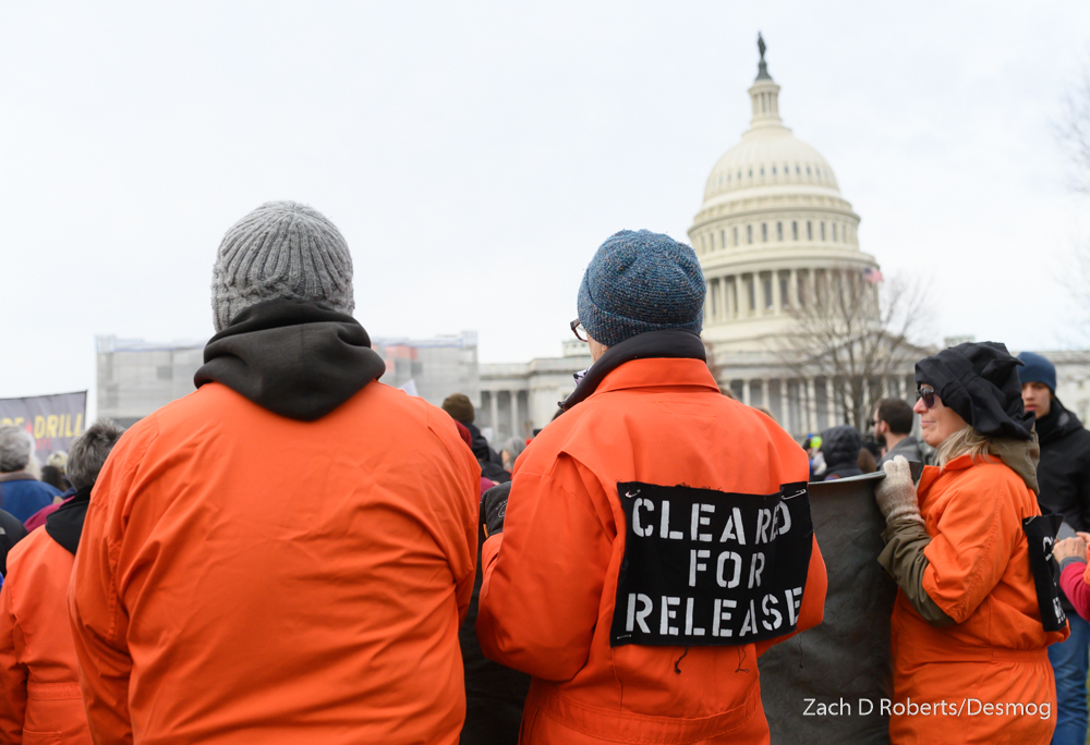 Rally-goers dressed in orange jumpsuits, anticipating arrests