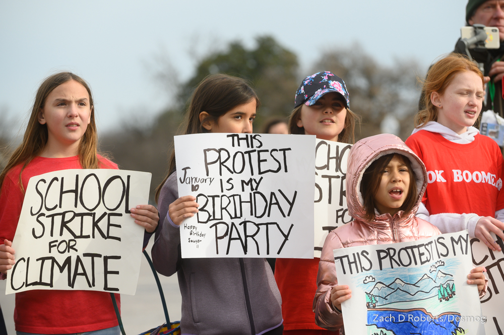 Children wearing 'OK boomers' shirts and chanting and holding signs