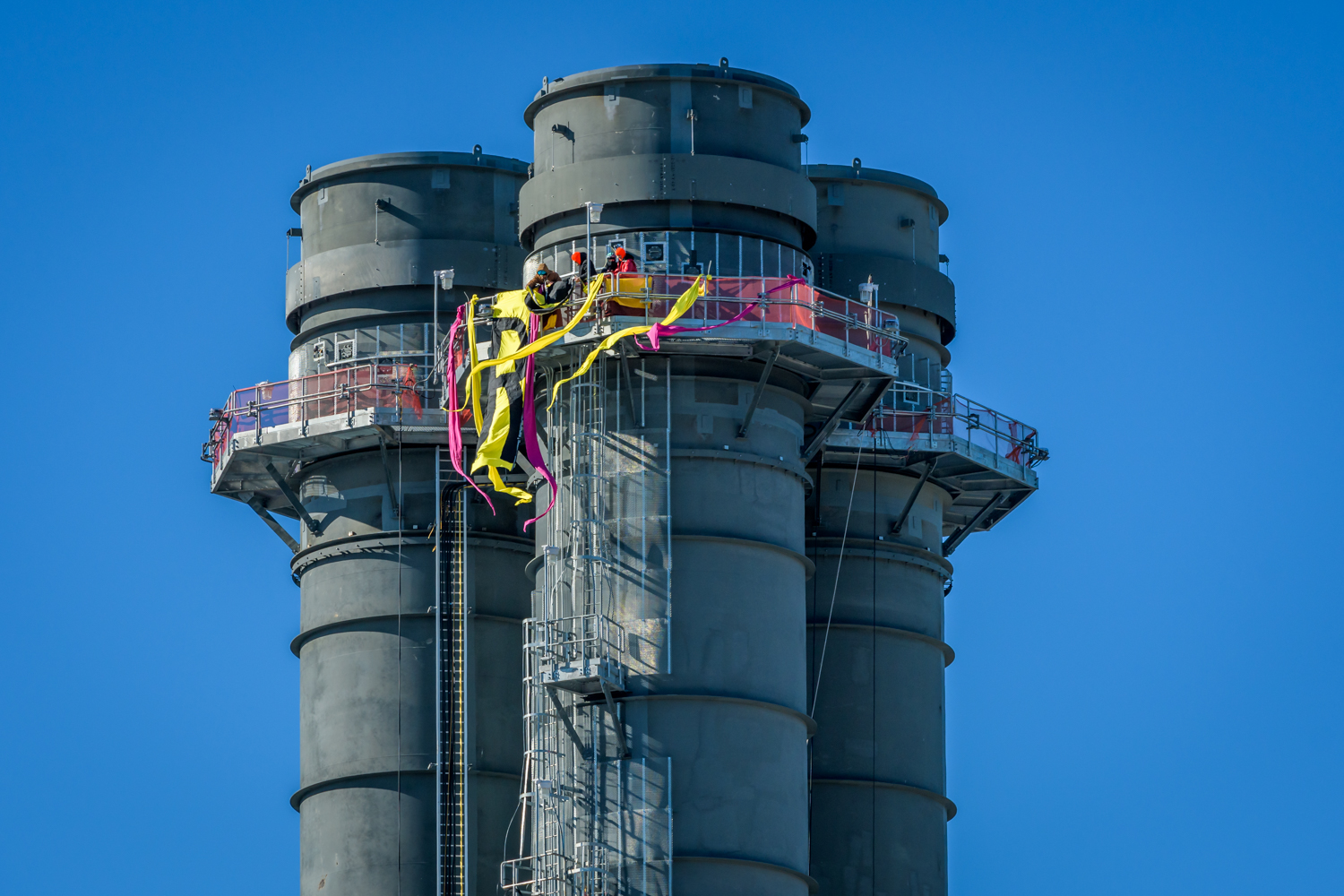 Four protesters, including two local farmers, climbed a smokestack to unfurl banners