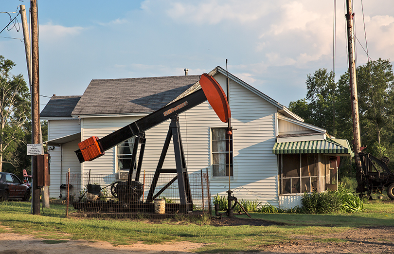 America's existing fossil fuel infrastructure, which in some cases sits close to homes and workplaces as this house in Hosston, Louisiana, illustrates, can complicate disaster recovery. 