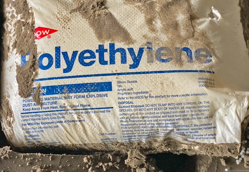 Dow Chemical bag of polyethylene plastic resin pellets under a wharf on the banks of the Mississippi River
