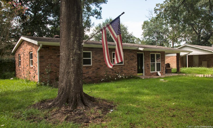 Empty home with torn American flag in Denham Springs, Louisiana