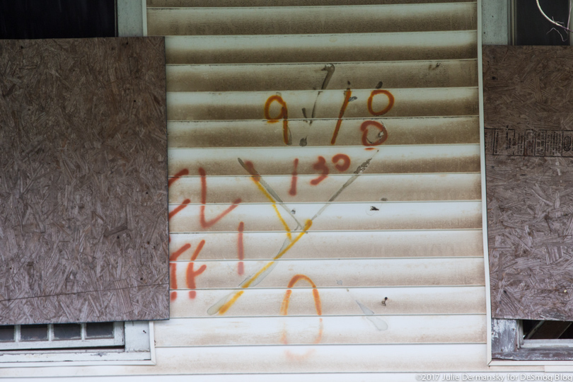 Spray painted signs by Hurricane Katrina search and rescue workers on a boarded-up home