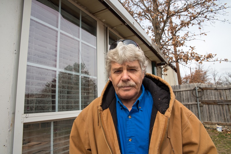 Daniel Hogan in front of cracked window at his house in Azle ©2014 Julie Dermansky