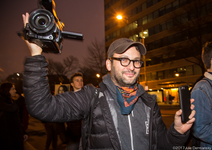 Director Josh Fox holds his camera above his head to shoot the actions of protesters