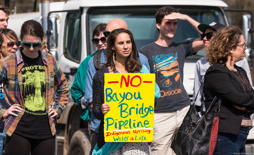 Bayou Bridge pipeline protesters hold signs