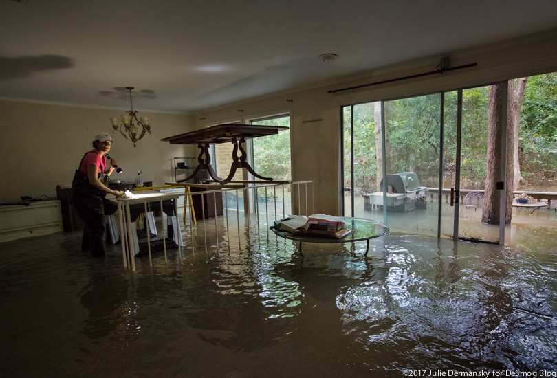 The Purcell family explores the flooded inside of their home, with a dining room table set above the water