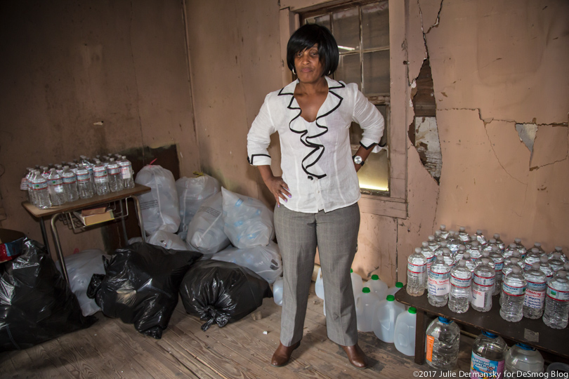 Wanda Bowman stands surrounded by her stockpile of bottled water.