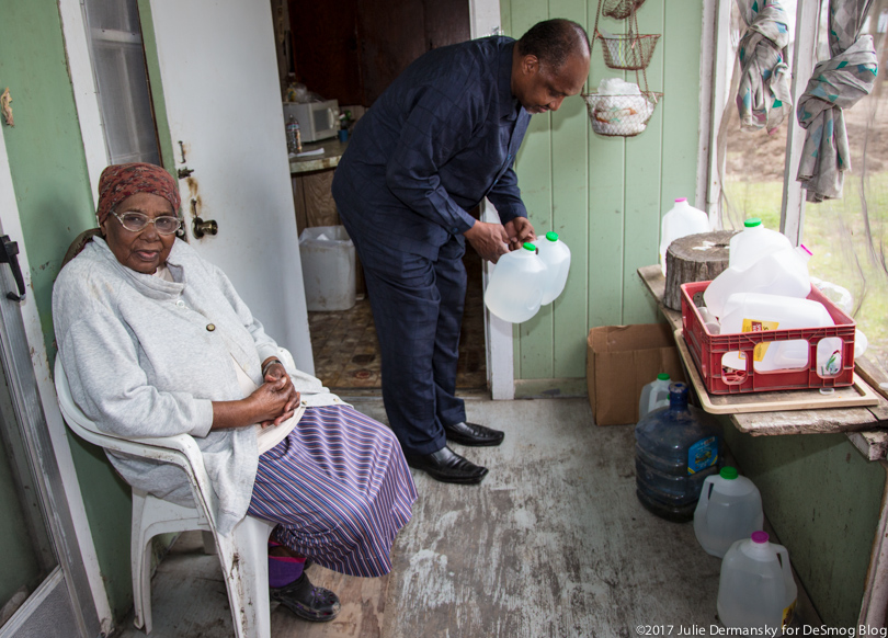 Roy Bowman delivers jugs of clean water to the home of Viola Marshall.