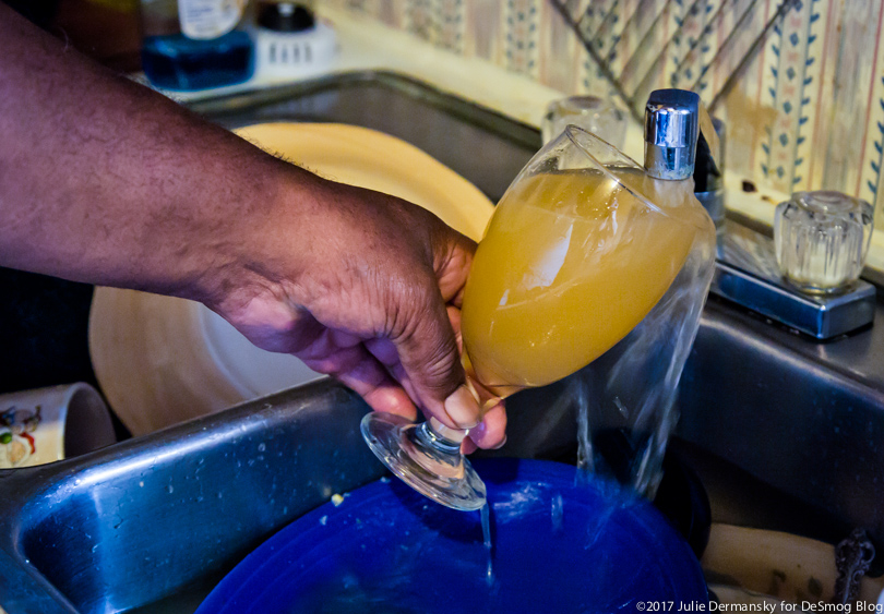 A resident of St. Joseph, Louisiana fills a glass with discolored water from his tap