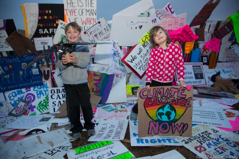 Two children play with signs left after the Women's March