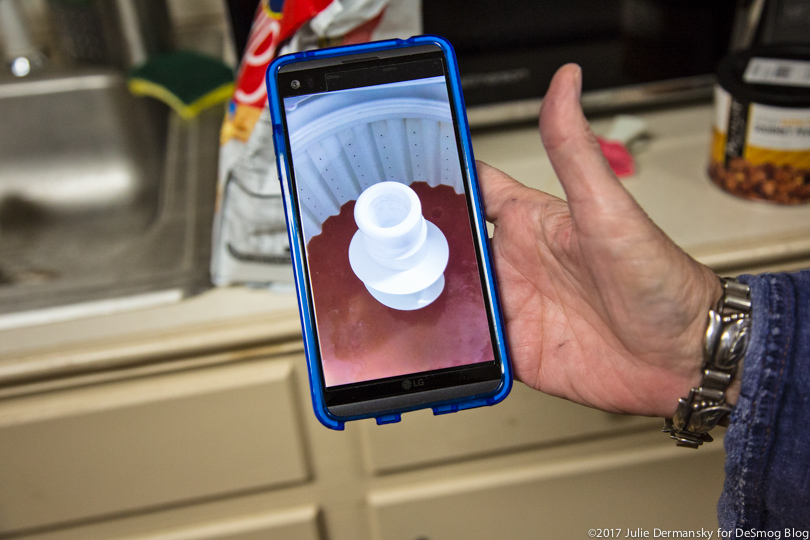 Valerie Sloan shows a photo on her phone of the dirty water filling her washing machine.