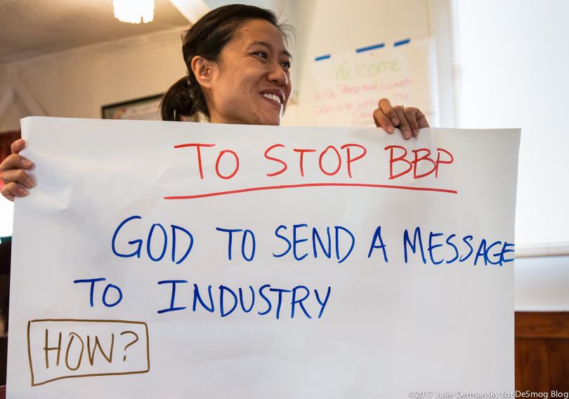 May Nguyen of Tulane Environmental Law Clinic holding a sign at a meeting about the Bayou Bridge pipeline