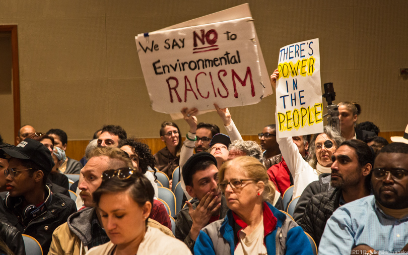 Opponents of Entergy's proposed gas plant in New Orleans hold signs calling out environmental racism