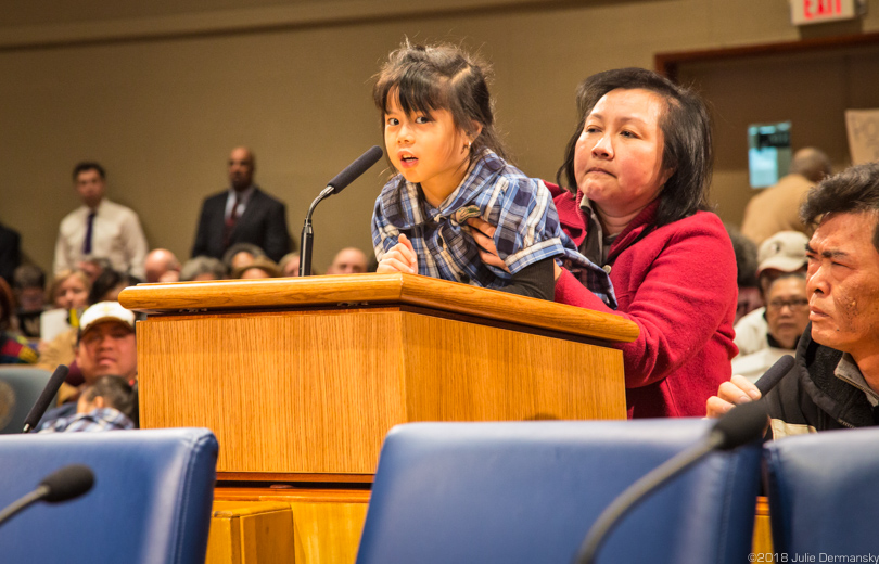 Christina Tran, age 5, addresses the New Orleans City Council, held up by Cam Tran