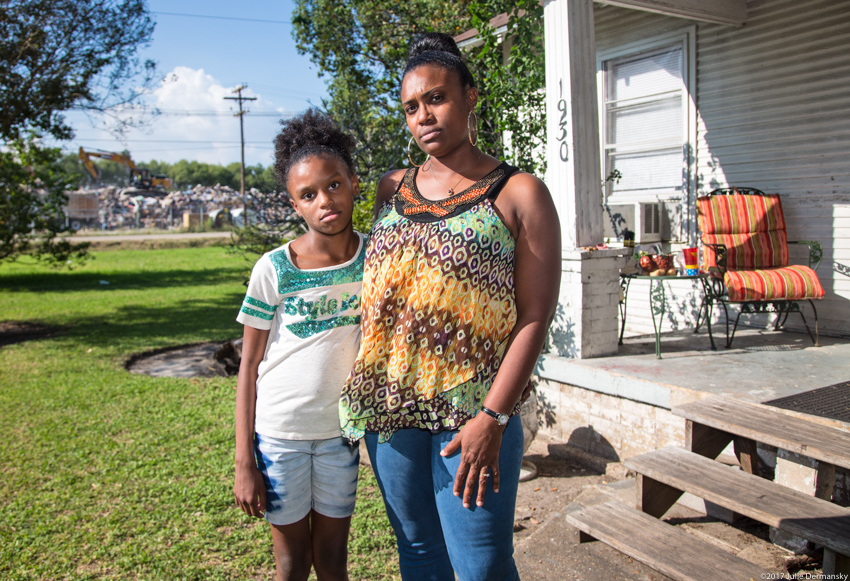 Tami Thomas-Pinkney and her daughter in front of their house across from a Hurricane Harvey debris temporary dump