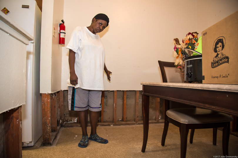 A Port Arthur, Texas, resident points to her flood-damaged walls after Hurricane Harvey