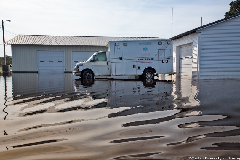 Floodwaters surrounding an ambulance.