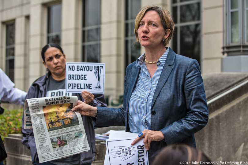 Anne Rolfes holds a newspaper while talking about a pipeline explosion at a press conference