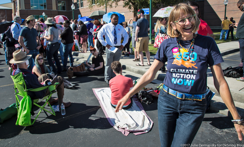 350 organizer Renate Heurich in front of the crowds outside Sen. Cassidy's town hall meeting in Metaire, Louisiana.