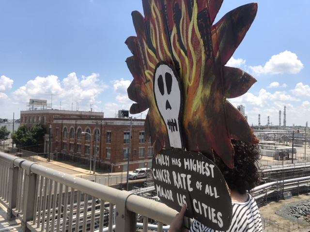 A Philly Thrive marcher passes by the PES refinery.