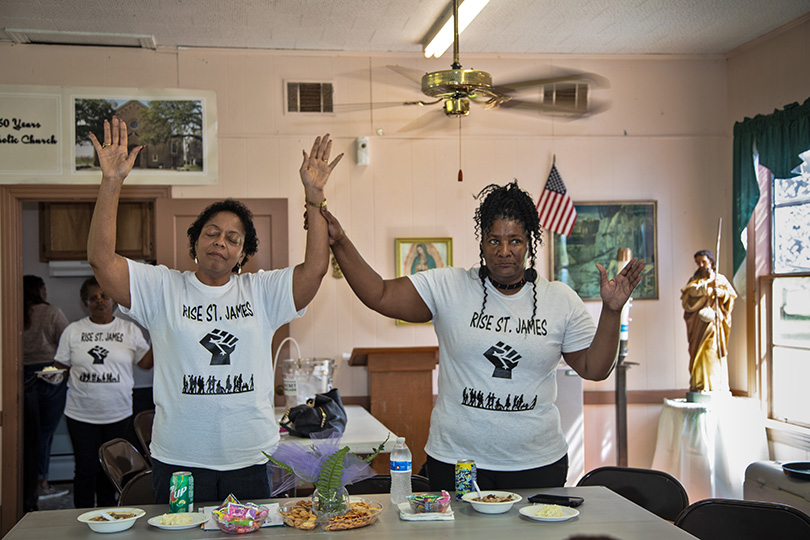 Sharon Lavigne with Stephanie Cooper, the Vice President of RISE St. James, praying at a meeting held in St. James