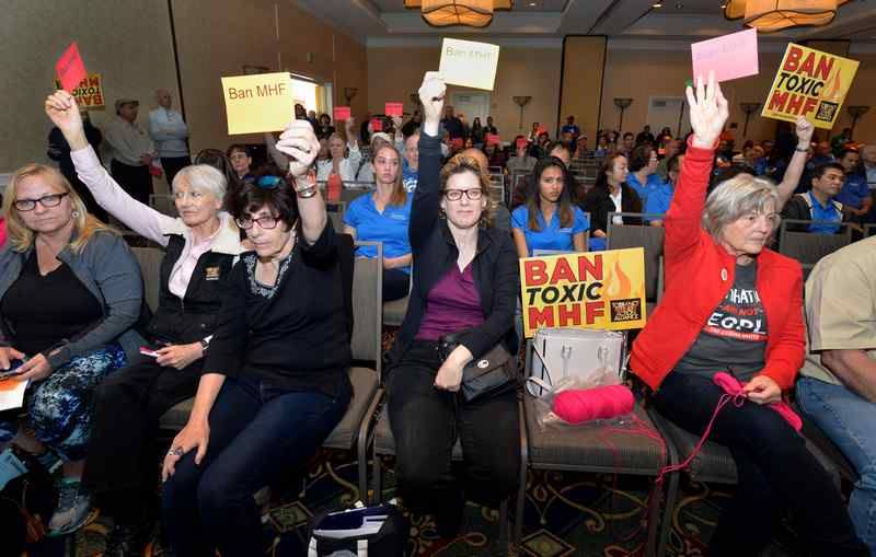 Community activists hold up anti-MHF signs at a Torrance, CA, City Council meeting