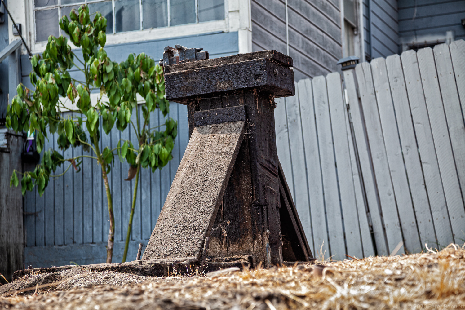 An old wooden base, once part of machinery used for oil production, sits in the front yard of a home along Court Street.