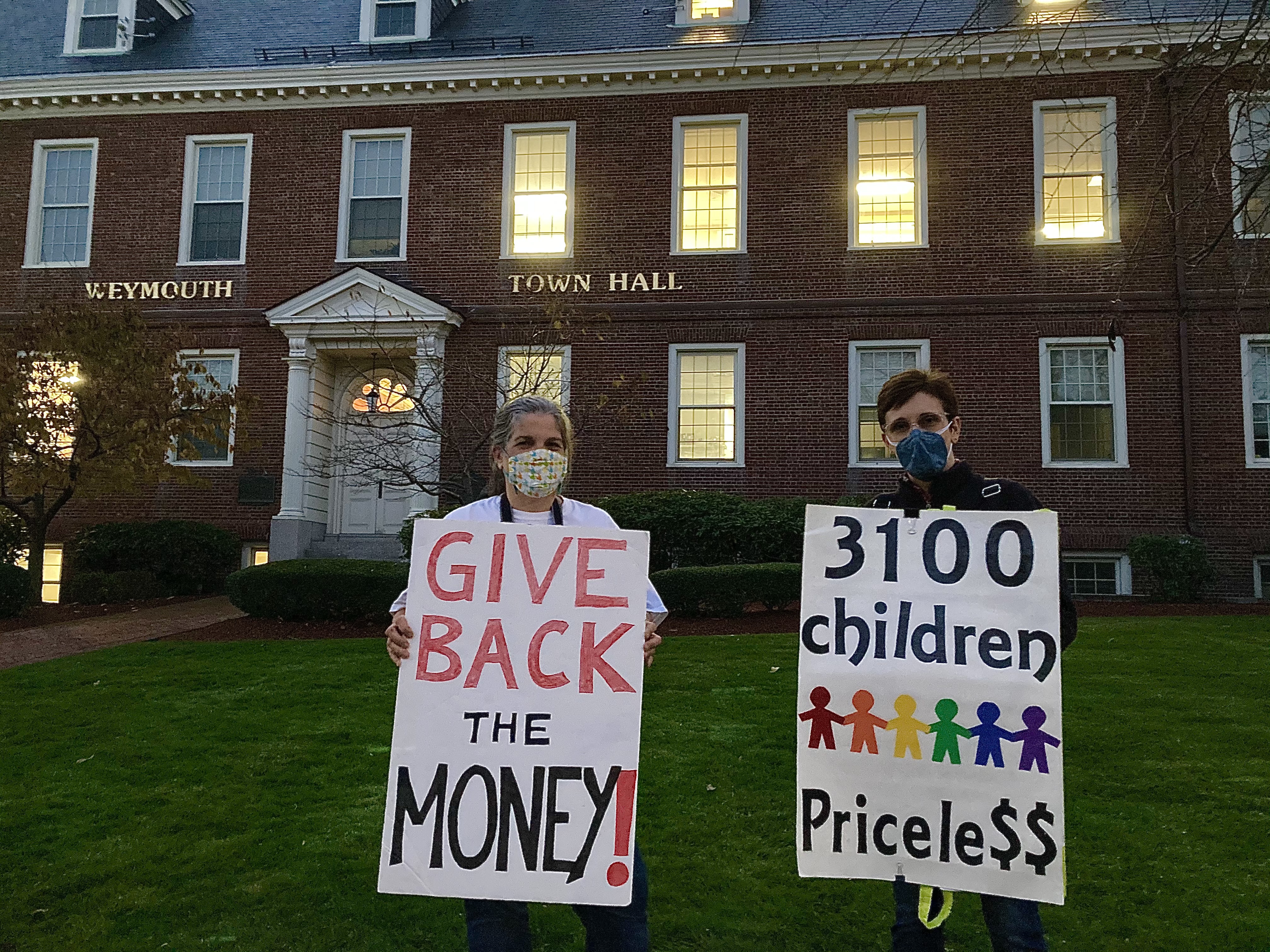 Lisa Jennings of Weymouth (left), and Suzanne Brothers of East Braintree (right), protest the Weymouth mayor's $10 million settlement deal with Enbridge outside Weymouth Town Hall on November 6, 2020. 