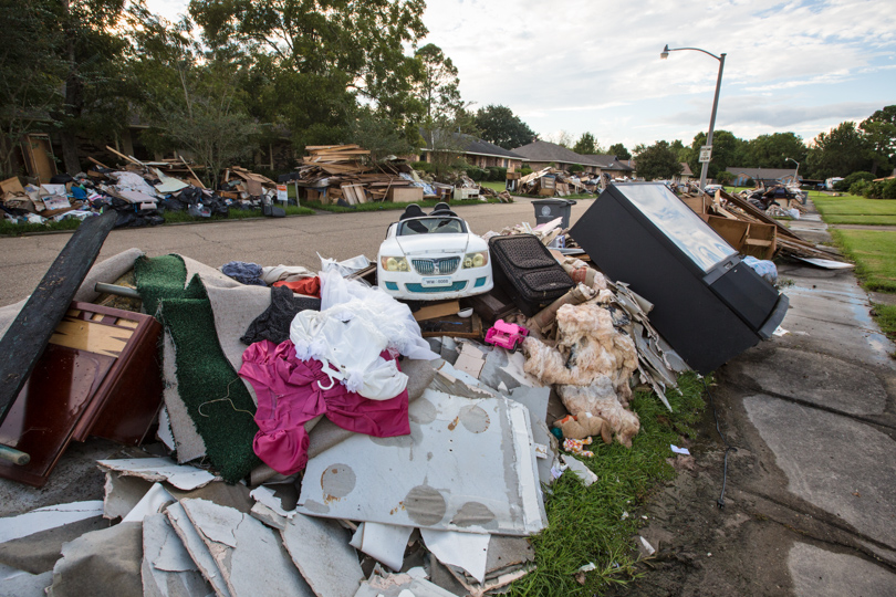 Ruined furniture and household items set on the street after Louisiana floods.
