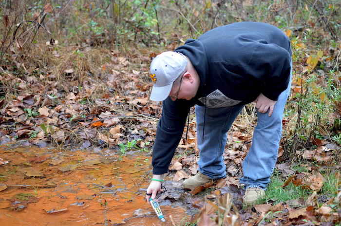 Dustin White tests a West Virginia stream for acid mine drainage pollution