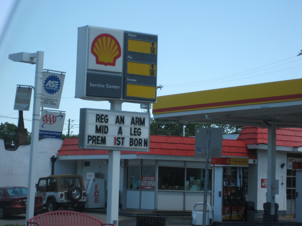 Gas station price sign lists the cost of regular (arm), mid (leg), and premium (first born).