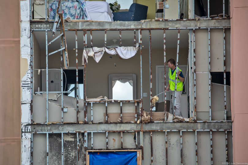 Person peering out of a damaged apartment building in Gulf Shores, Alabama, after Hurricane Sally.